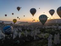 Sonnenaufgang hinter schwebenden Heißluftballonen